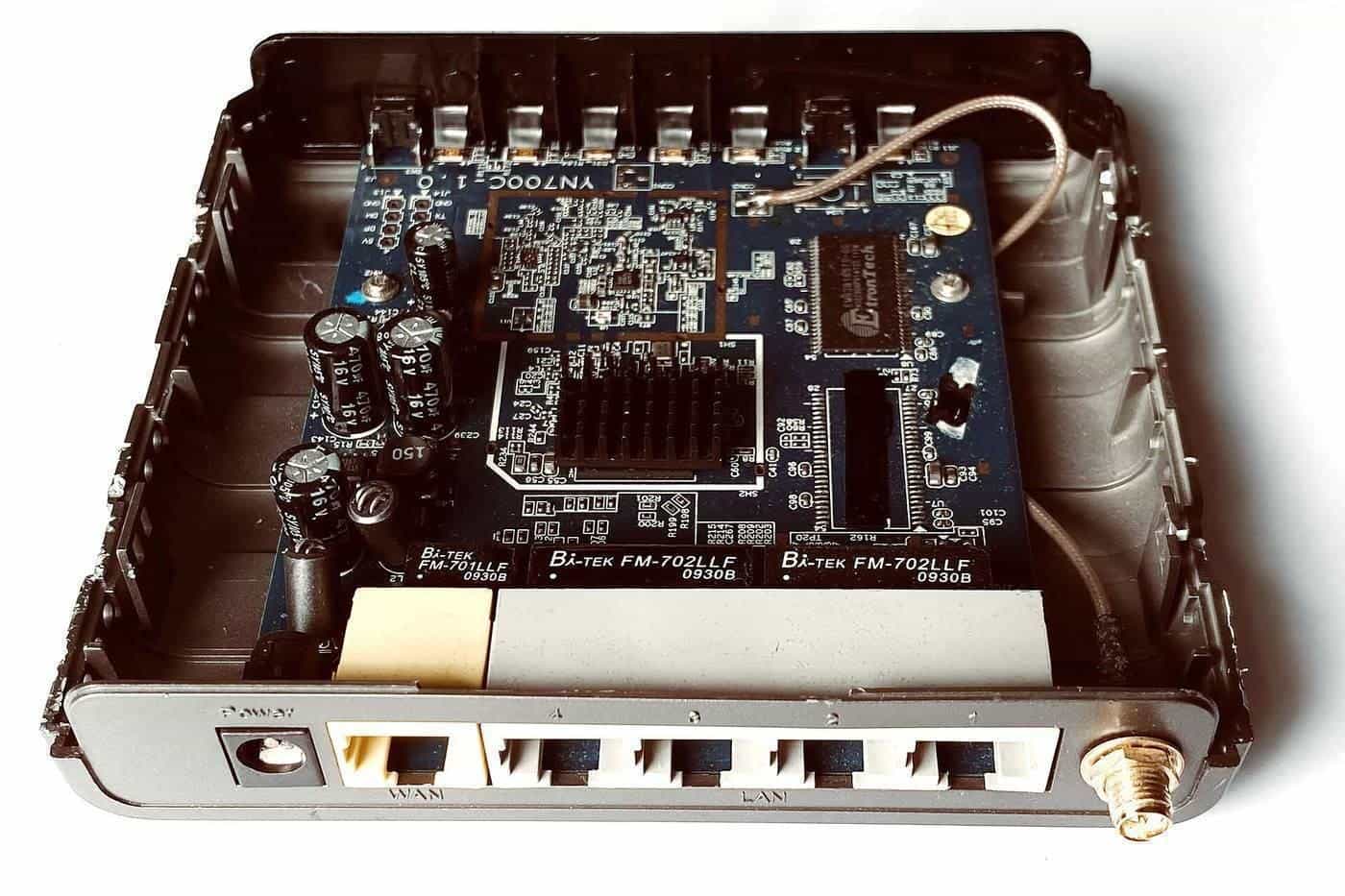 Inside of a home router showing its circuit board and network ports