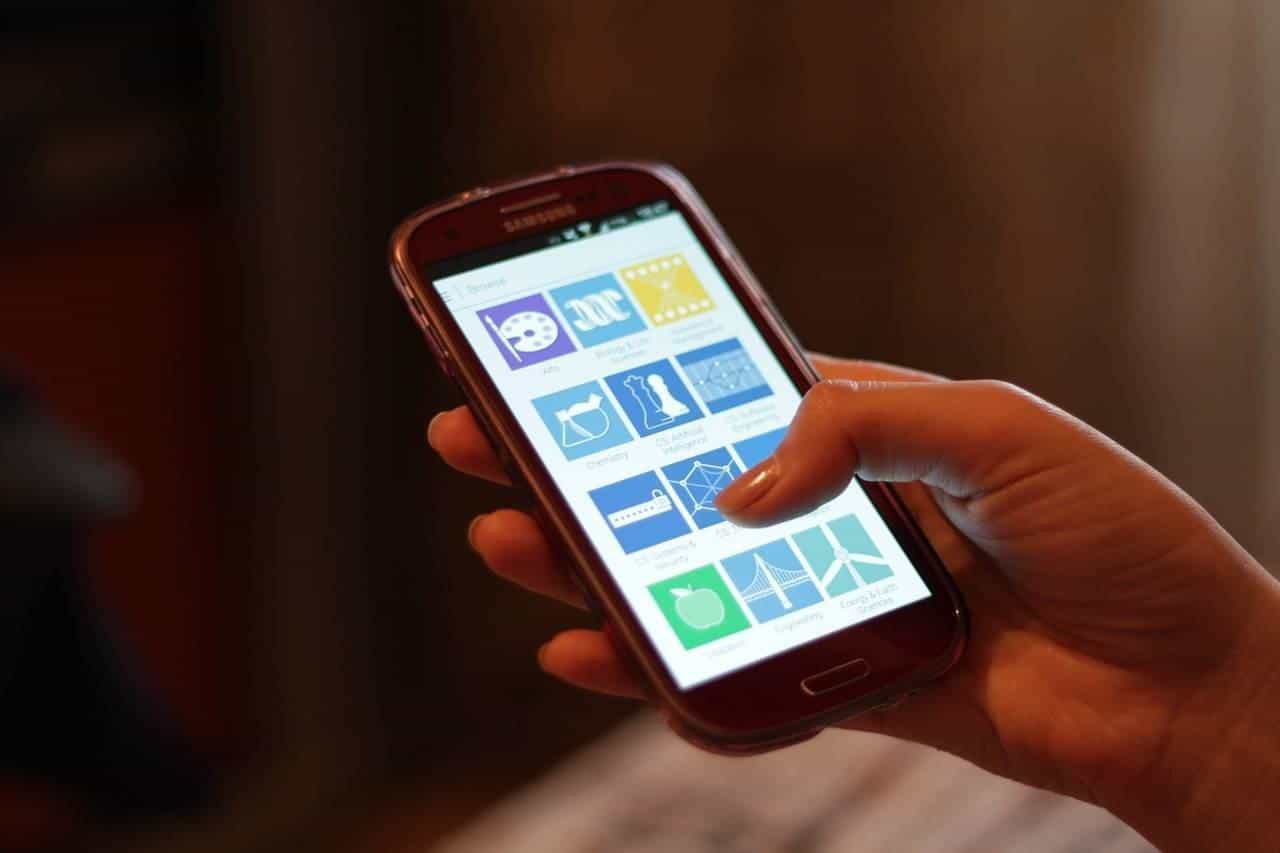 Person holding a smartphone showing app icons