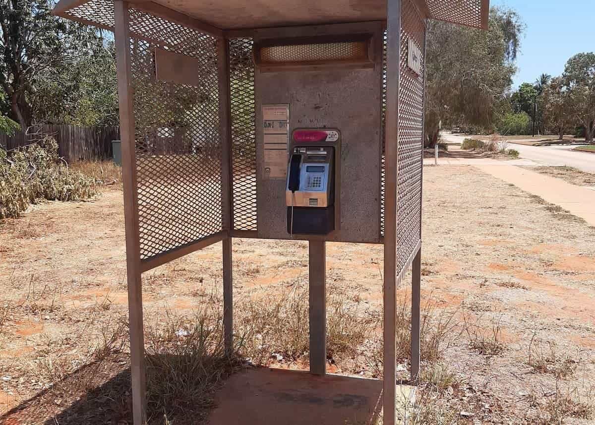 Public payphone in a simple shelter on a dirt verge in a country town