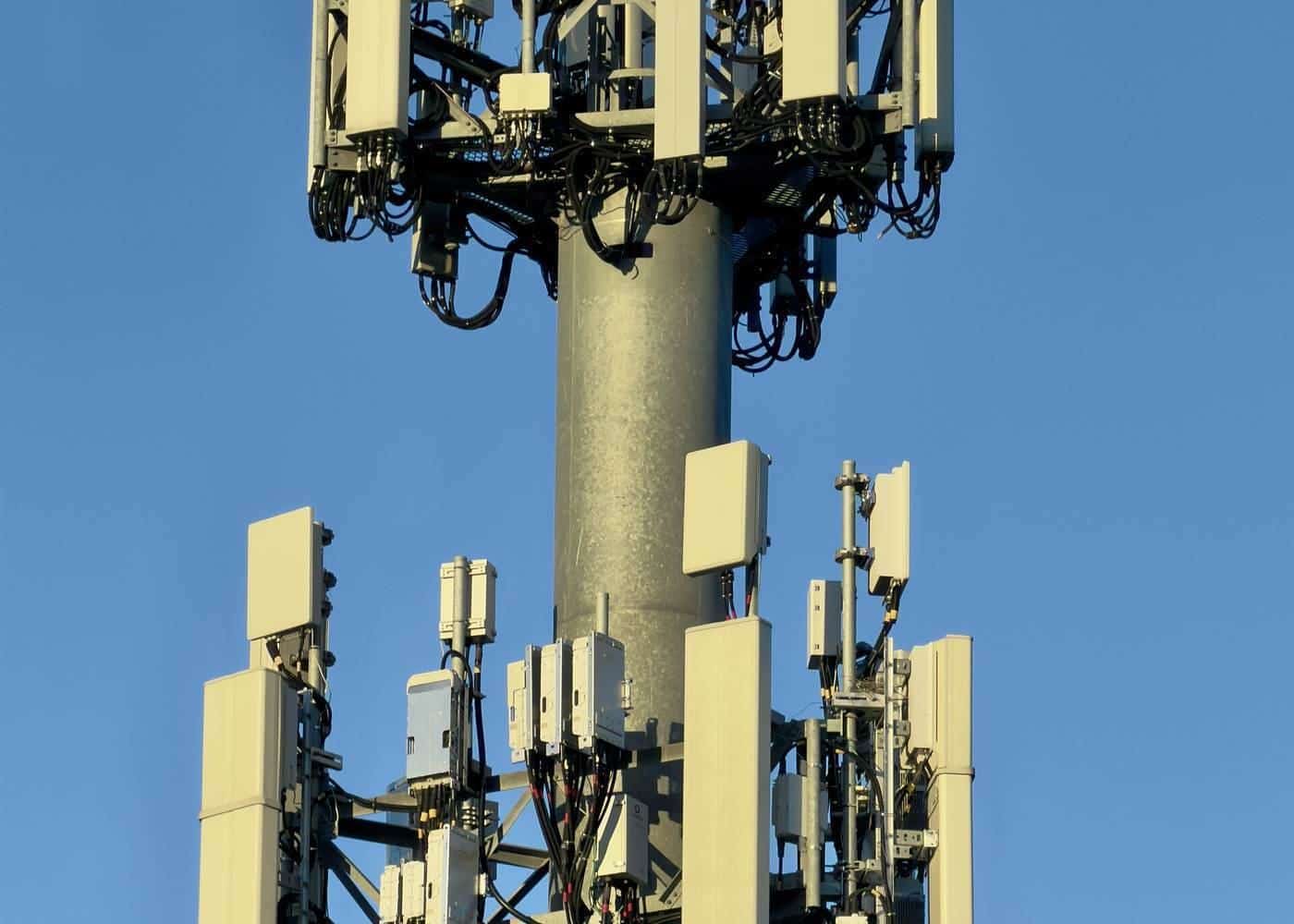 Close-up of antennas on a mobile phone tower against a blue sky