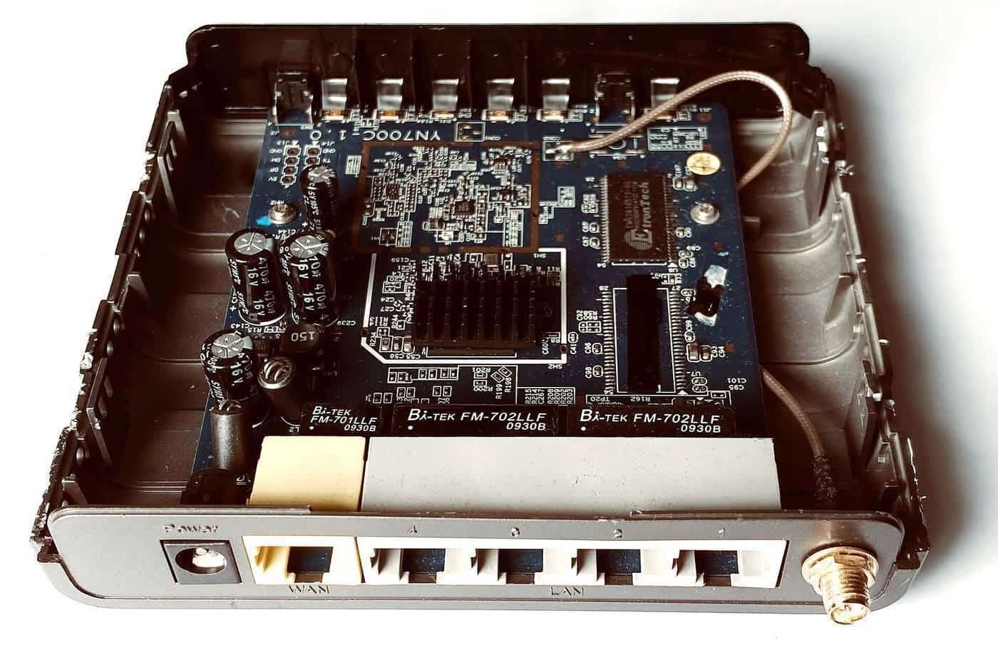 Inside of a home router showing its circuit board and network ports