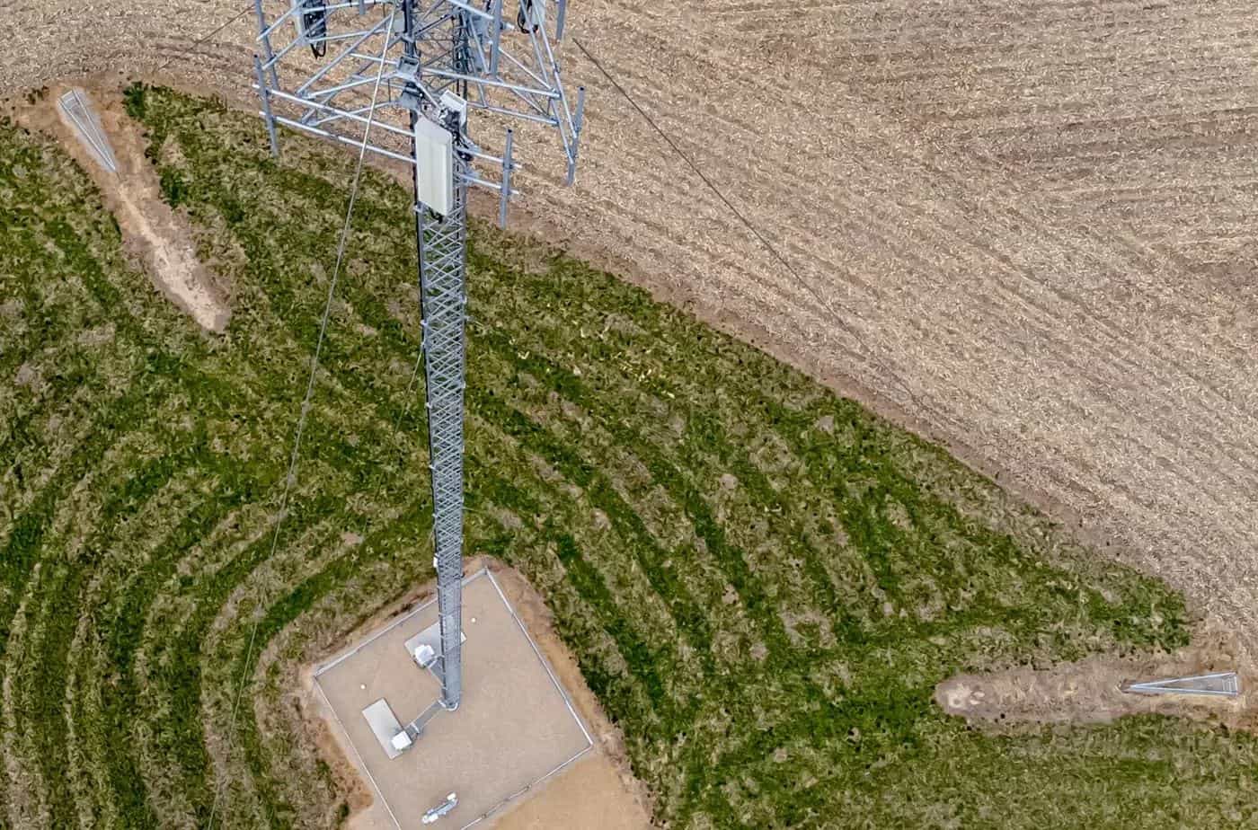 Aerial view of a lattice mobile phone tower standing in a farm paddock