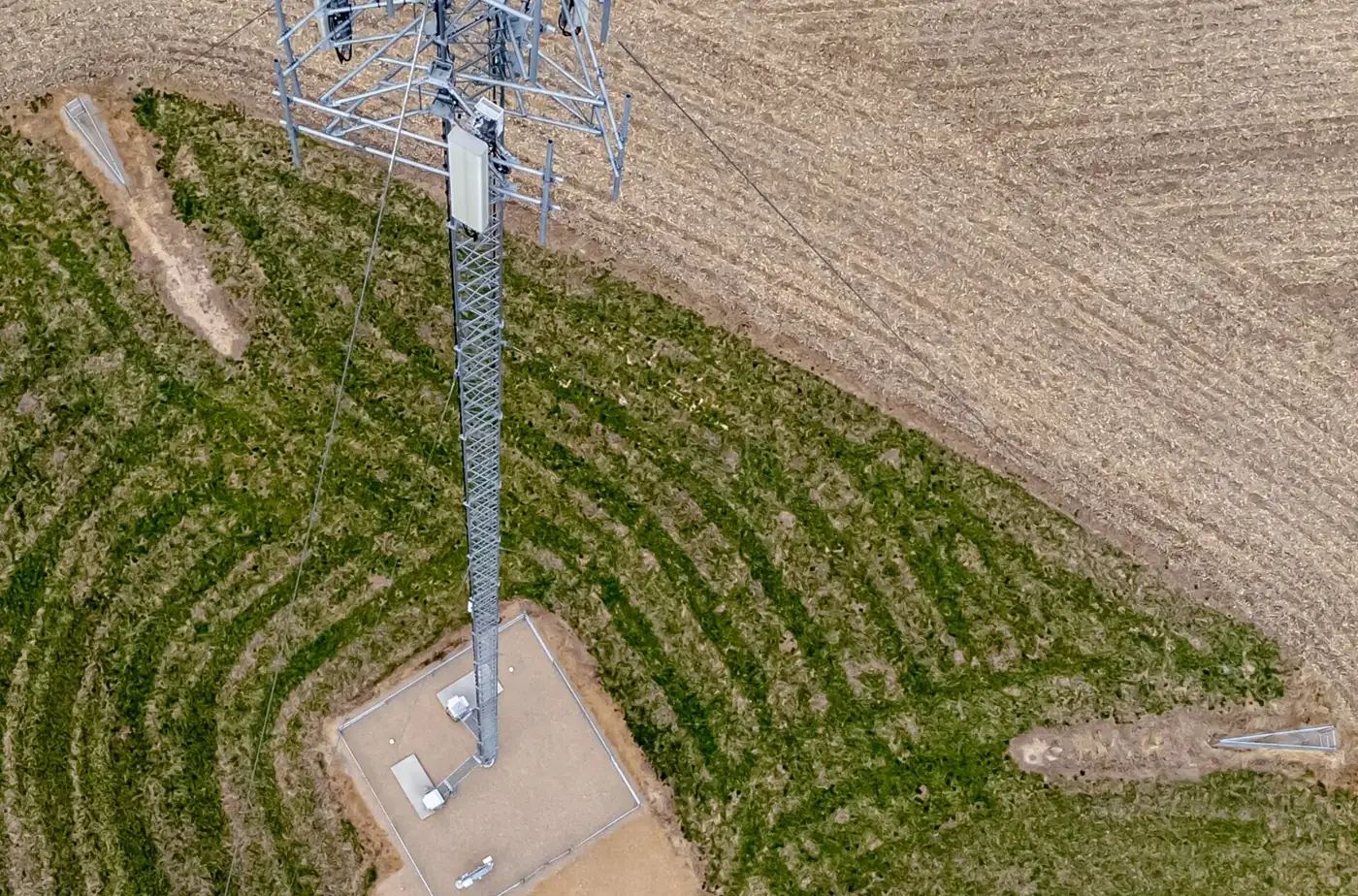 Aerial view of a lattice mobile phone tower standing in a farm paddock